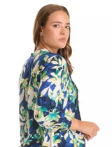 Blusa Ruby Rd de manga larga con puños elastizados, cuello a la base con escote en V y botones frontales. Presenta un diseño delantero plisado y un estampado floral en tonos azules, verdes y blancos.