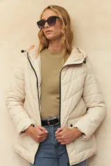 Campera puffer color verde oliva, con capucha, cierre frontal, bolsillos laterales con solapa y elástico en la cintura.