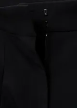 Pantalón wide leg de tiro medio color negro, con diseño largo, bolsillos laterales, bolsillos de ribete posteriores y detalle de pinzas. Cuenta con cierre oculto de botón, gancho y cremallera, e incluye forro interior.