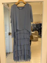Vestido midi celeste con diseño de múltiples capas y volados con terminaciones deshilachadas, escote redondo y mangas cortas holgadas.