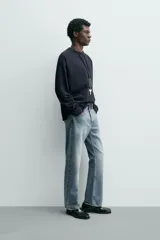 Camiseta de manga larga con cuello redondo, confeccionada en algodón compacto y pesado, con diseño de corte relajado y costuras decorativas en el cuello.