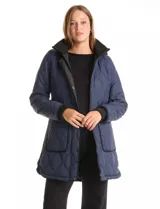 Campera capitoneada de corte largo, color negro, con cierre frontal oculto y botones a presión. Presenta cuello alto y puños en tejido elastizado, bolsillos frontales amplios y forro interno.