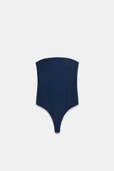 Body strapless de corte ajustado, confeccionado en tejido de poliamida, con cierre inferior mediante botones a presión.