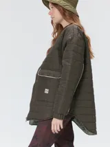 Campera reversible capitoneada con cierre frontal. Un lado es de color negro y el otro es de color beige, ambos con diseño acolchado. Cuenta con cuello redondo, mangas largas y bolsillos laterales.