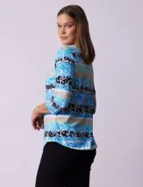 Remera de algodón con estampado floral y de rayas horizontales en tonos azules, negros y beige. Presenta escote redondo a la base y mangas tres cuartos.