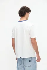 Remera celeste de manga corta con cuello redondo en color tostado y diseño bordado en el pecho.
