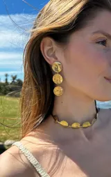 Aros colgantes dorados con tres círculos texturizados.