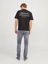 Jean de corte ajustado y tiro bajo, confeccionado en denim gris con acabado lavado. Cuenta con diseño clásico de cinco bolsillos y cierre frontal con botón.
