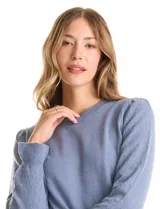 Buzo de tejido de punto gris, con cuello redondo, mangas largas con diseño de rombos calados y detalle de volado en los puños. Presenta hombros ligeramente fruncidos y terminaciones en rib acanalado.