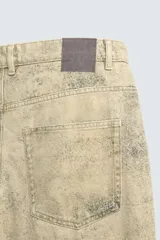 Pantalón de corte baggy fit confeccionado en tejido de algodón con textura y efecto lavado. Presenta diseño de cinco bolsillos, cierre frontal con cremallera y botón.