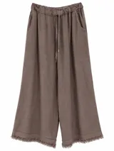Pantalón ancho color visón de lino, con cintura elástica ajustable con cordón y detalle de flecos en el ruedo.
