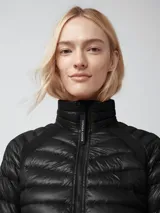 Campera acolchada de diseño técnico, color negro, con cierre frontal completo y cuello alto. Presenta paneles laterales elásticos para mayor movilidad y un acabado brillante en el cuerpo principal.