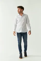 Camisa de hombre de corte slim, manga larga, con cuello clásico y cierre frontal de botones. Presenta un diseño de cuadros finos y logo bordado en el pecho.