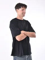Remera negra de manga corta y corte oversize, con cuello redondo.