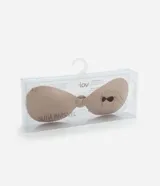 Soutien adhesivo color beige, sin breteles ni espalda, con copas moldeadas y cierre frontal tipo clip. Incluye protectores de pezón redondos adhesivos.