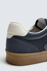 Zapatillas deportivas de hombre, color azul marino, con detalles en blanco y suela color caramelo.