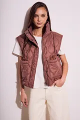 Chaleco acolchado color marrón con cierre frontal y bolsillos laterales.