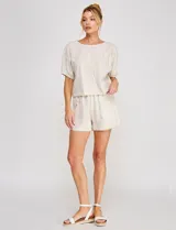 Blusa corta de lino y viscosa color beige, con bordado de grandes flores al tono, cuello redondo, mangas cortas abullonadas y corte holgado.