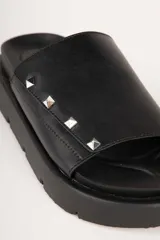 Sandalias negras de tira ancha en símil cuero con apliques de tachas y plataforma de 4cm de alto.