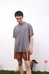 Remera gris de algodón con efecto acid wash, cuello redondo y mangas cortas. Presenta un pequeño logo estampado en el pecho y un estampado más grande en la espalda.