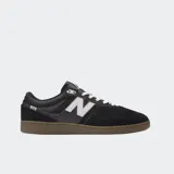Championes urbanos New Balance modelo 508, color negro con detalles en gris y blanco, confeccionados en gamuza y malla, con logo "N" característico en los laterales y entresuela marrón.