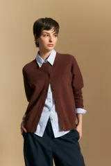 Cardigan de tejido de punto color rojo, con cuello redondo, cierre frontal de botones al tono y puños acanalados.