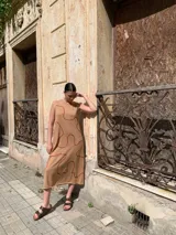 Vestido midi sin mangas color beige con estampado de líneas onduladas color ladrillo.