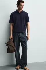 Polo de punto azul marino, de corte regular fit, con cuello solapa, abertura frontal en V y mangas cortas.