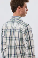 Camisa de manga larga de calce slim, con diseño a cuadros en tonos azul oscuro, verde y blanco. Presenta cuello camisero con botones y bolsillo ojal en el pecho con detalle bordado.