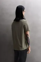 Camiseta de entrenamiento regular fit color beige, confeccionada en combinación de tejidos técnicos ligeros y elásticos con tecnología Quick Dry nivel 2. Presenta cuello redondo, manga corta, acabados con costuras planas y termofijadas, y detalle de logo estampado en el bajo.