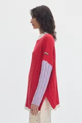 Buzo de punto oversized con diseño colorblock en celeste, rojo, blanco y lila. Presenta cuello redondo, tejido de ochos, pequeños tajos laterales y parche de la marca en la manga.