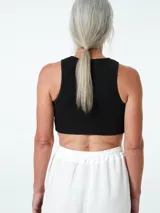 Top negro ajustado al cuerpo, con cuello redondo y cierre frontal con botones.