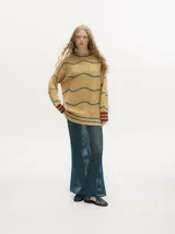 Conjunto de tejido calado color azul petróleo con detalles en amarillo. Incluye un cárdigan corto con botones y una falda larga recta con pretina elástica.