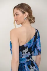 Vestido midi de gasa con estampado floral en tonos azules y negros, diseño asimétrico de un solo hombro y falda fluida con corte irregular.