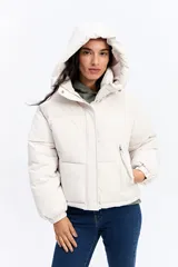 Campera puffer color crema con capucha, cuello alto, cierre frontal y puños elásticos.