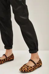 Pantalon cargo de corte recto y acabado satinado, color negro, con bolsillos laterales tipo cargo y puños elásticos en los tobillos.