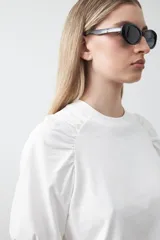 Remera blanca de manga corta confeccionada en algodón, con calce cómodo y mangas levemente abullonadas.