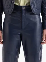 Pantalon de cuero ovino con silueta curva tipo barrel, de tiro alto y diseño estructurado con costuras reforzadas en las rodillas.