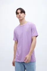 Remera lila de manga corta con estampa fotográfica en la espalda que muestra un paisaje de atardecer sobre el mar.