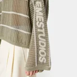 Suéter de tejido de punto calado color verde militar con rayas horizontales blancas, cuello redondo, hombros caídos y mangas amplias con logo de la marca tejido en el lateral.