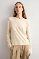 Sweater clásico de punto color beige, de cuello redondo y manga larga con diseño ajustado.