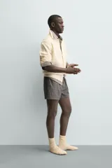 Cárdigan de ajuste relajado, tejido en hilado con lana, color crema. Presenta cuello solapa, manga larga y textura de punto trenzado en todo el cuerpo. Cierre frontal con botones.