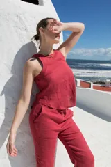 Top sin mangas de lino, con cuello redondo y cierre posterior mediante tres lazos. Diseño minimalista y versátil.