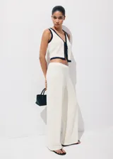 Pantalón blanco de tiro regular con diseño de pernera recta y estructura de tejido plano ligero.