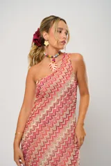 Vestido midi de crochet con diseño de ondas en tonos rojo, rosa y beige. Tiene un solo hombro y tajos laterales.