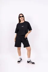 Bermuda negra de corte holgado con cintura elastizada y logo estampado en blanco en la pierna izquierda.