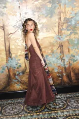 Vestido largo negro de encaje con escote profundo halter, espalda abierta, detalles fruncidos al cuerpo y falda larga semitransparente con tiras largas para atar.