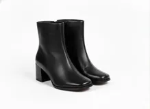 Botas de caña corta confeccionadas en cuero negro con textura granulada, diseño de punta cuadrada y taco bloque de altura media.