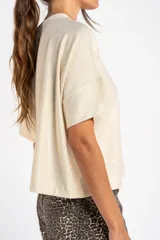 Remera color crema con brillo, de corte amplio y mangas cortas.