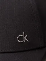 Gorra negra de algodón orgánico con logo CK metálico en el frente.